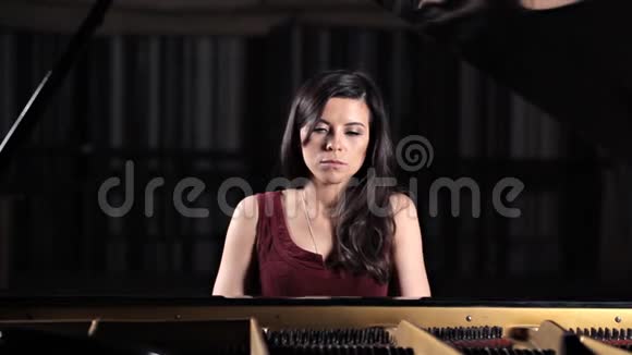 年轻漂亮的女士在弹钢琴为照相机摆姿势视频的预览图