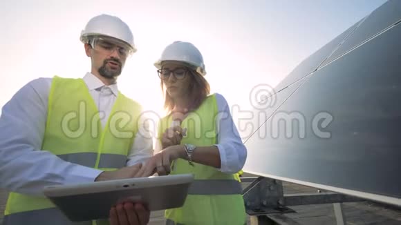 女建筑师在太阳能电池附近与男工程师交谈的工程师替代能源概念视频的预览图