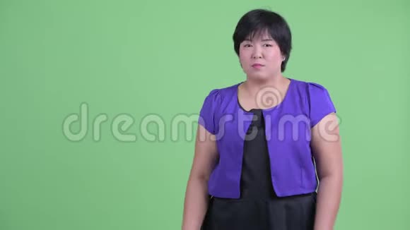 快乐年轻体重超重的亚洲女人展示了一些东西看上去很惊讶视频的预览图