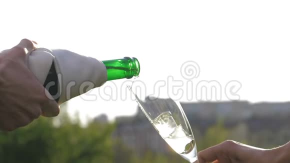 香槟被倒进玻璃里在自然背景上溅出玻璃视频的预览图