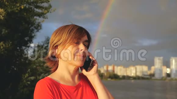 快乐的中年妇女站在湖边微笑着彩虹视频的预览图