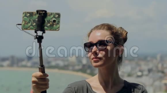 快乐的旅行者女人正在拍照年轻女孩用手机自拍坚持在夏天的城市城市生活理念视频的预览图