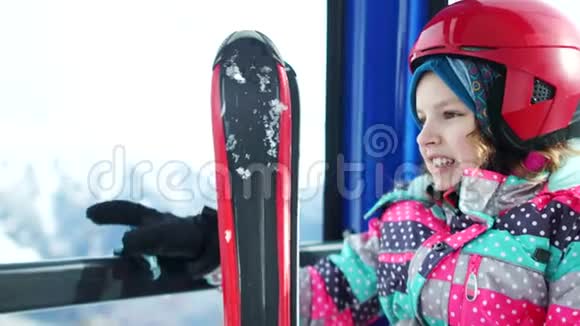 雪山背景上的近距离画像戴着头盔和滑雪板的少女爬上了一座山视频的预览图