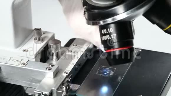 研究人员或科学家在显微镜上用样品支架上的标本换镜片视频的预览图