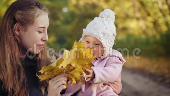 带着妈妈在秋天公园微笑的小女孩视频的预览图