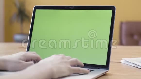 一个男人在家工作使用带有绿色屏幕通信和商业概念的笔记本电脑库存录像男子视频的预览图