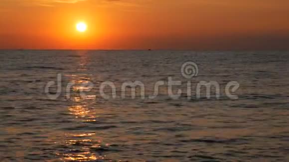 在海面上巨大的圆圆的红色的日落或黎明在海面上反射阳光和日出视频的预览图