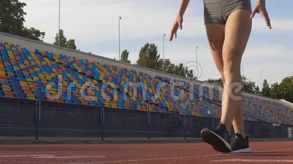 自信的女人准备在体育场的起跑线上奔跑慢动作视频的预览图