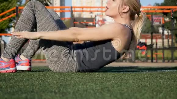 美丽的年轻女孩在做运动躺着视频的预览图