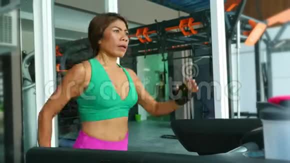 年轻的健康和运动的亚洲泰国妇女与健康的身体跑步健身房跑步机出汗训练硬慢跑锻炼视频的预览图