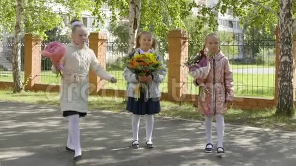 三个快乐的女学生带着花束回到学校视频的预览图