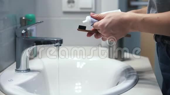 女人挤管把牙膏放在刷子上视频的预览图