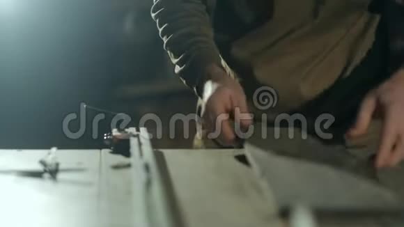 一个专业的木匠在圆锯桌上定义一块长方形木头的正确位置视频的预览图