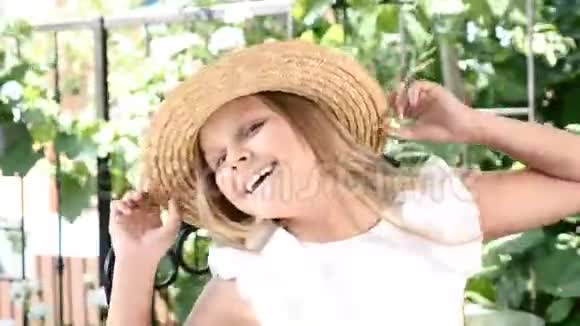 可爱的小女孩戴着草帽对着镜头笑着快乐的童年概念暑假4k视频的预览图