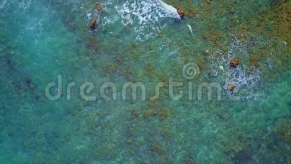 在印度尼西亚巴厘岛的热带海滩上用无人驾驶飞机在令人惊叹的海面上空飞行在海浪中追踪海水的颜色视频的预览图