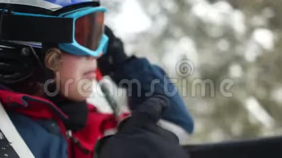 一个十几岁的男孩戴着头盔戴着护目镜坐在滑雪缆车舱里滑雪胜地家庭度假快乐视频的预览图