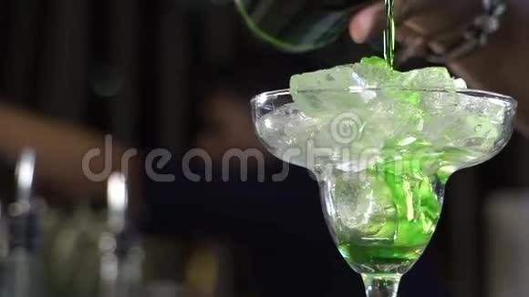 绿色利口酒倒入装有冰块的玻璃杯中视频的预览图