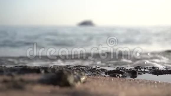 海浪冲刷着海岸在背景中缓缓航行着游艇视频的预览图