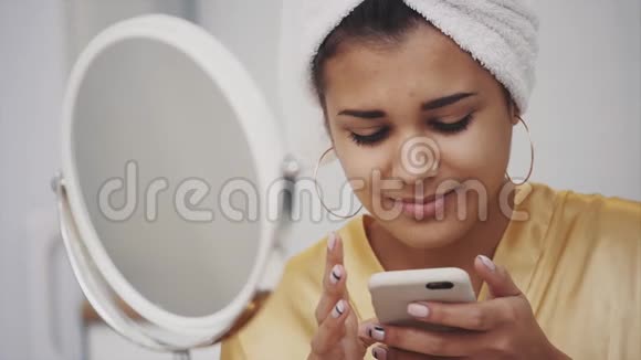 一个年轻的女人早上醒来卧室里头上戴毛巾的快乐女孩好的肤色地点和地点视频的预览图