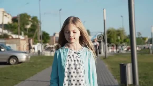 美丽的小女孩在阳光明媚的码头在镜头前走来走去视频的预览图