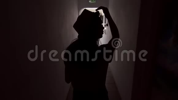 夏女剪影走在漆黑的走廊里酒店内的步行女孩视频的预览图