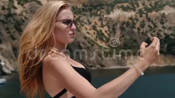 令人惊叹的金发美女在智能手机上自拍慢动作出现在海湾视频的预览图