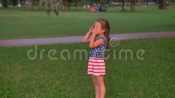 年轻的一家人夏天在公园里散步玩捉迷藏女儿数数发现她的父母视频的预览图