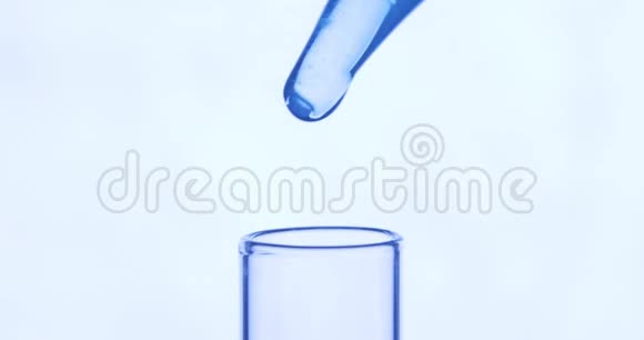 吸管将透明蓝色化学物质滴入白色背景的试管中化学和医学概念视频的预览图