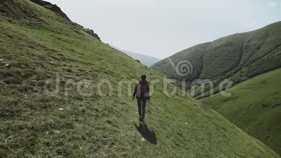 女孩旅行者沿着山径在山顶上越过峡谷的悬崖视频的预览图