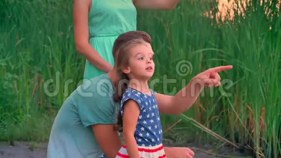 英俊的父亲指着什么他的女儿听他的家庭观念在夕阳下漫步在公园里视频的预览图