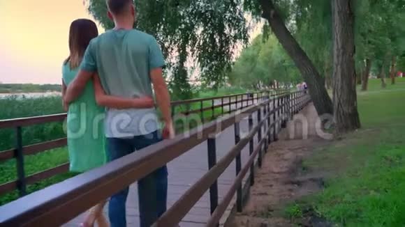 夏天日落时分一对夫妇正沿着公园的小路散步视频的预览图