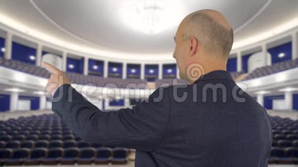 商务人员用食指指着会议厅的演示屏幕视频的预览图