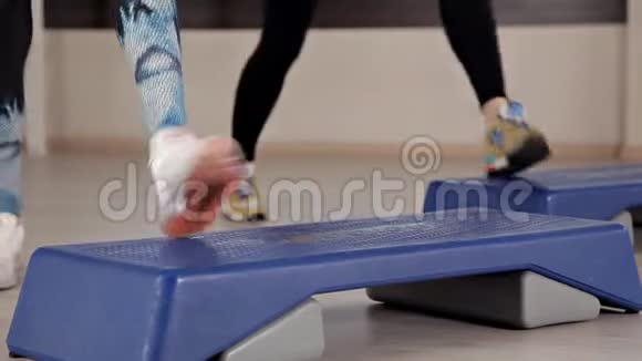 阶梯平台穿运动鞋的女孩做健身操健身房减肥的概念视频的预览图