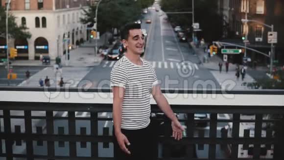 慢动作快乐的西班牙男人微笑着高兴地遇见欧洲女孩抱着她在纽约的一座桥上旋转视频的预览图