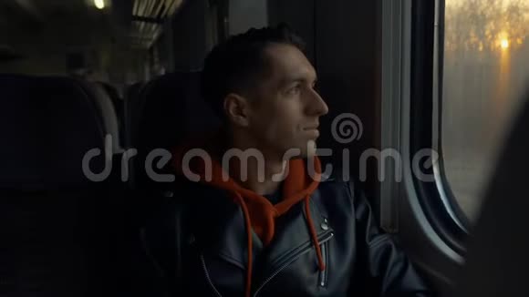 有火车旅行的年轻人日落时分坐火车的人从窗外眺望视频的预览图