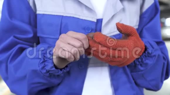 汽车机械师专家在与机器一起工作后摘下脏橙色手套并在咪唑类中表现出肮脏的双手视频的预览图