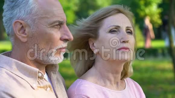 老人坐在公园里靠近女人搂着她的肩膀他们向前看视频的预览图