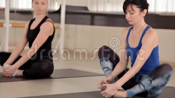 女孩在有氧运动课上微笑着做运动健身教练在健身房和一个女孩合作视频的预览图