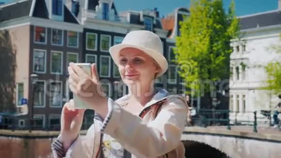 一位女游客在运河附近一个风景如画的地方拍照荷兰旅游业视频的预览图