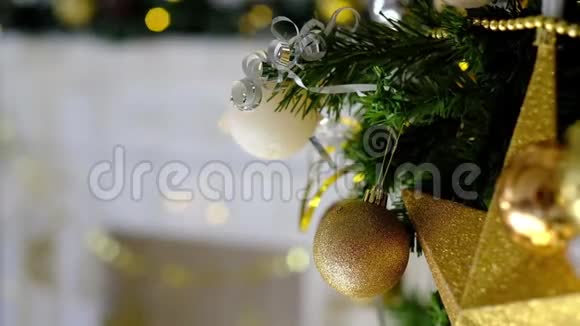 女人手用金色玩具装饰圣诞树背景上的仙女灯视频的预览图