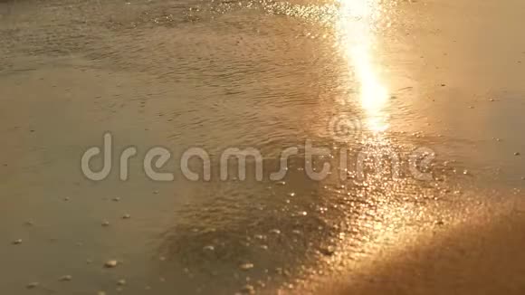 金色的阳光洒在沙滩和海浪上视频的预览图