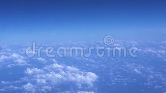 阳光明媚的天空和蓬松的云层从窗户飞机上看到从飞行飞机到蓝天白云的视野视频的预览图