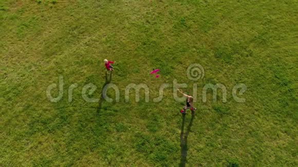 一位年轻女子和她的小儿子在公园里玩塑料飞机的俯视镜头视频的预览图