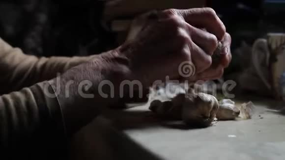 一位生病的老妇人在乡下老厨房做饭前把大蒜的头擦干净摸一摸视频的预览图