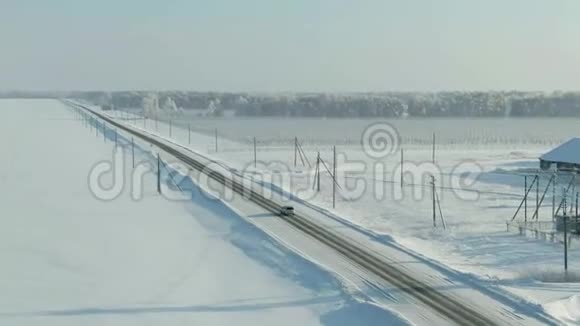 在白雪皑皑的森林里骑着车鸟瞰雪林松树高路上有车视频的预览图