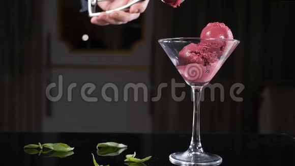 一位厨师用薄荷叶装饰一个冰淇淋盘餐厅提供冰淇淋甜点厨师装饰薄荷叶视频的预览图