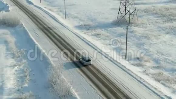 在白雪皑皑的森林里骑着车鸟瞰雪林松树高路上有车视频的预览图