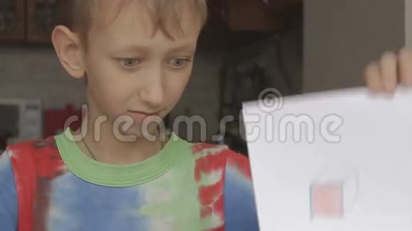 一个男孩展示了一个立方体的图片视频的预览图