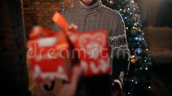 一个快乐的人收到一份红色包装的圣诞礼物视频的预览图