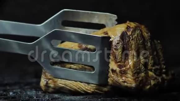 牛肉或牛肉肉放入铁钳中烤制特写镜头视频的预览图